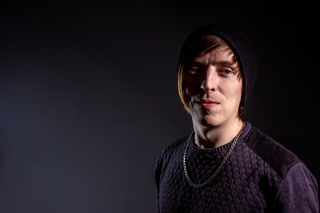 Photo of a serious young American guy informal in tatto Studio with pulsed light on the background...