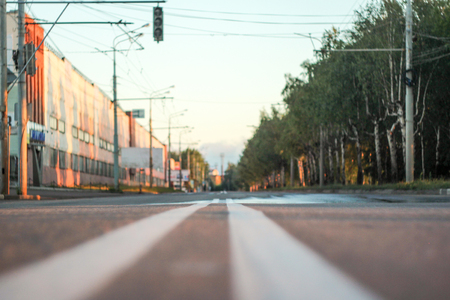 Photo of the road with a double solid strip with a small depth of field, blurred background and variable focus for wallpaper at sunriseの写真素材
