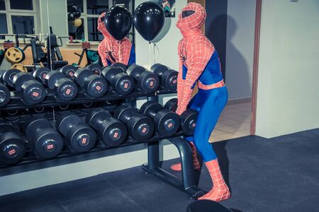 RUSSIA, YAROSLAVL - 17 NOV. 2018: Animators iron man and spider man in the fitness gym with bodybuilding equipment. Toned.のeditorial素材