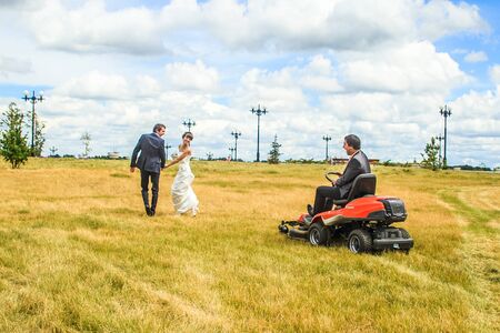 RUSSIA, YAROSLAVL -  19 JULY. 2012: The bride and groom run away from the master of ceremonies on a...