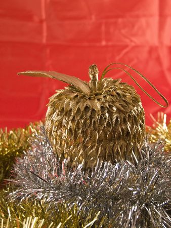 A golden apple christmas tree decoration surrounded with tinselの写真素材
