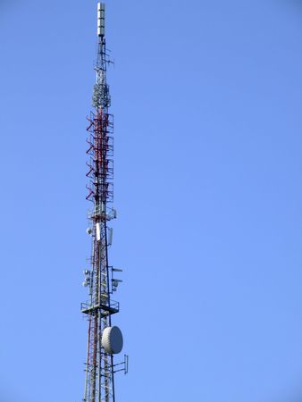 Communications mast set against a blue summer skyの写真素材