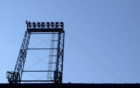 a football stadium floodlights silhouetted against a summer blue skyの写真素材