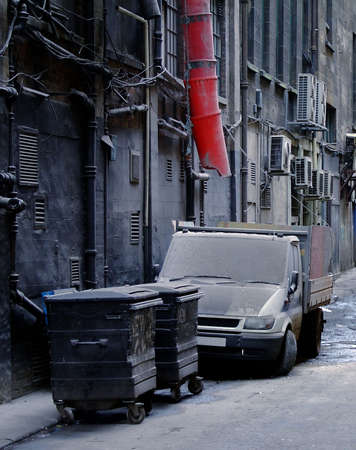 A filthy looking works van parked next to a trash can in a dirty city back street alley in Glasgow.の写真素材