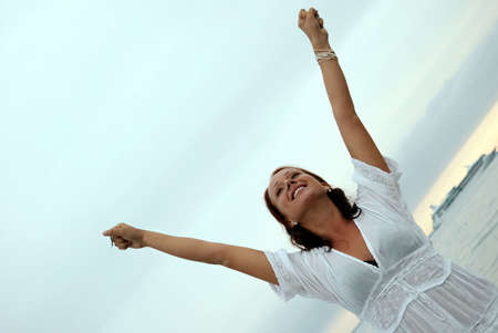 A beautiful, fit and healthy young woman throws her hands in the air in a fit of joy.の写真素材