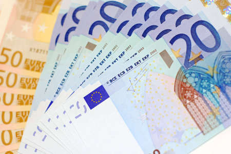 A pile of euro dollars lying on a white surface.