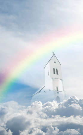 A heavenly rainbow set against a beautiful cloudscape and church.の写真素材