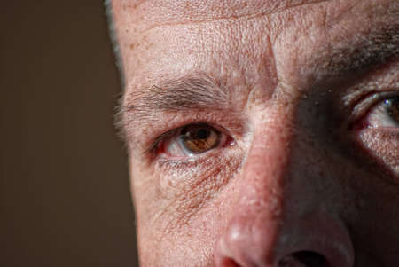 An image of a middle aged man staring at you from the shadows.の写真素材