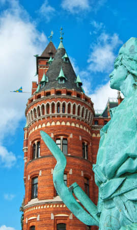 A statue in front of the impressive town hall in Helsingborg with selective focus used to highlight the statue.の写真素材