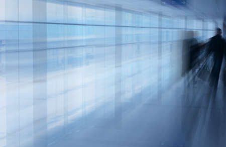 An interior view of passengers walking along a corridor of a busy international airport.の写真素材