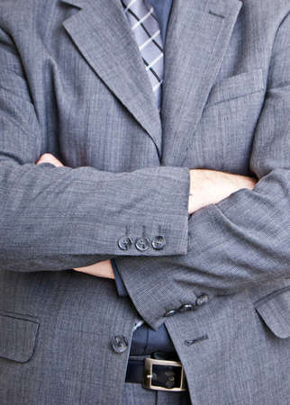 A close up shot of a business man standing with folded arms filling the entire frame of the photo.の写真素材