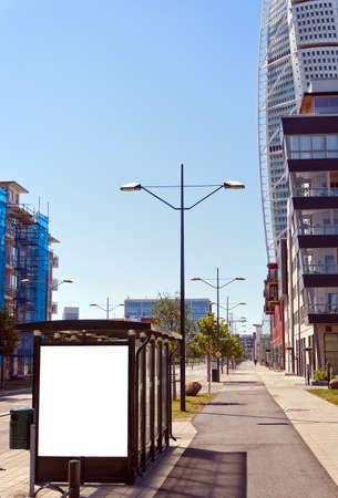 An image of a bus stop with a blank bilboard for your advertising situated in front of the turning torso skyscraper in the swedish city of Malmo.の写真素材