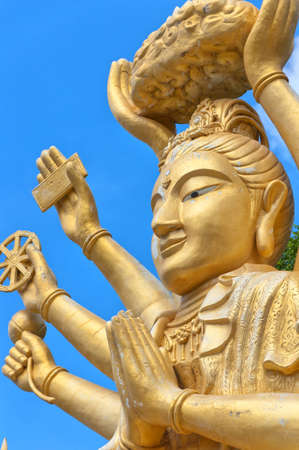 A huge statue of a multi armed buddha sits on a hill near to the city of Hua Hin in Thailand.の写真素材