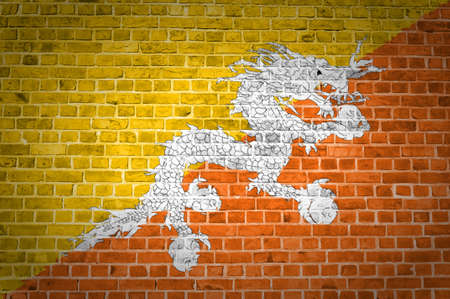 An image of the Bhutan flag painted on a brick wall in an urban locationの写真素材