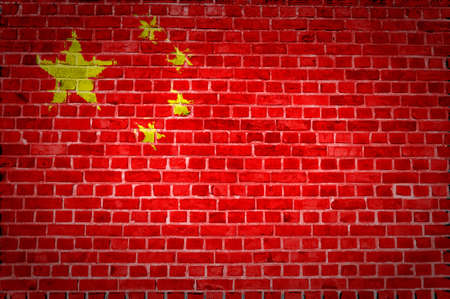 An image of the China flag painted on a brick wall in an urban locationの写真素材