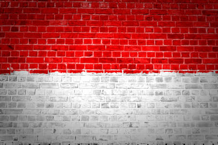 An image of the Indonesia flag painted on a brick wall in an urban locationの写真素材