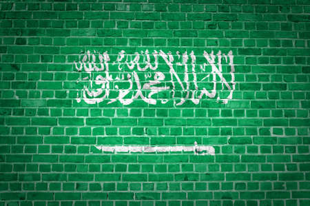 An image of the Saudi Arabia flag painted on a brick wall in an urban locationの写真素材