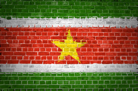 An image of the Suriname flag painted on a brick wall in an urban locationの写真素材