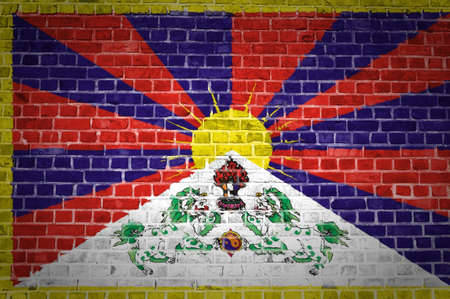 An image of the Tibet flag painted on a brick wall in an urban locationの写真素材