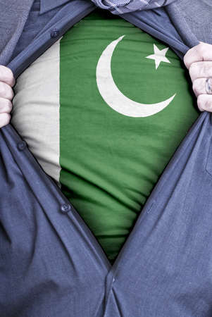 A Pakistani businessman rips open his shirt and shows how patriotic he is by revealing his countries flag beneath printed on a t-shirtの写真素材