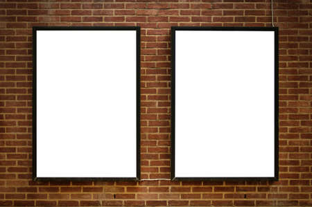 Two blank billboards attached to a buildings exterior brick wall.
