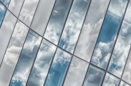 A close up shot of an average corporate buildings glass facade reflecting the sky.の写真素材