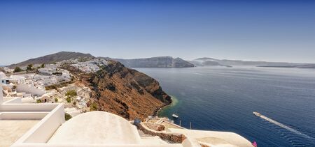 A panoramic image from Santorini of the village of Oia with Imerovili and Fira in the distance.の写真素材