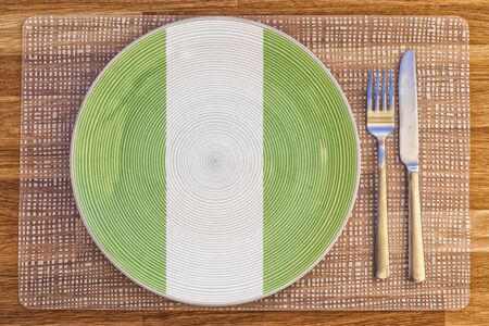 Dinner plate with the flag of Nigeria on it for your international food and drink concepts.の写真素材