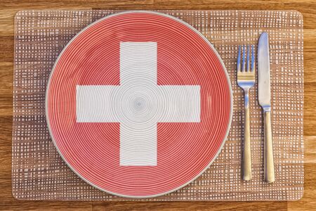 Dinner plate with the flag of Switzerland on it for your international food and drink concepts.の写真素材