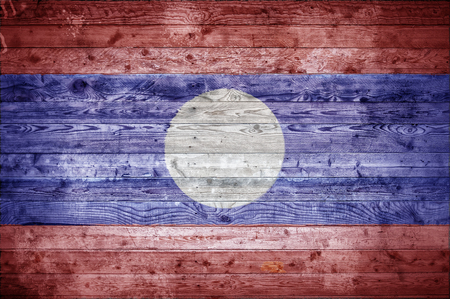 A vignetted background image of the flag of Laos painted onto wooden boards of a wall or floor.の写真素材
