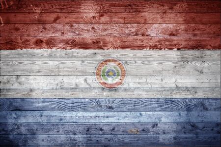 A vignetted background image of the flag of Paraguay onto wooden boards of a wall or floor.の写真素材