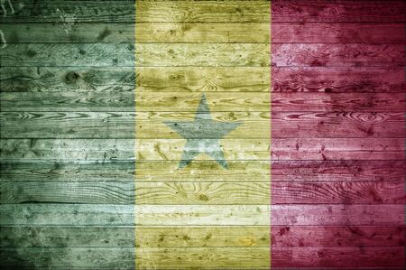 A vignetted background image of the flag of Senegal onto wooden boards of a wall or floor.の写真素材