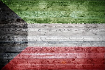 A vignetted background image of the flag of Kuwait painted onto wooden boards of a wall or floor.の写真素材