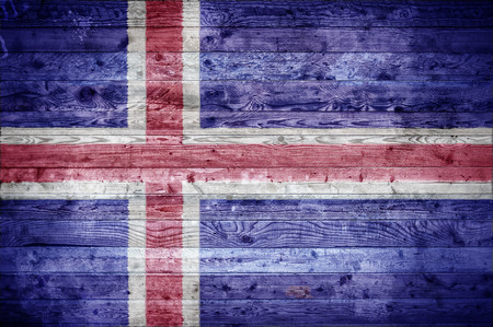 A vignetted background image of the flag of Iceland painted onto wooden boards of a wall or floor.の写真素材