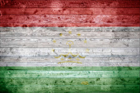 A vignetted background image of the flag of Tajikistan onto wooden boards of a wall or floor.の写真素材