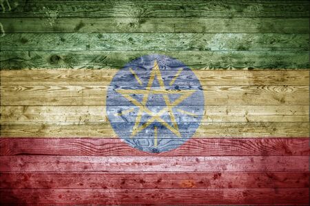 A vignetted background image of the flag of Ethiopia painted onto wooden boards of a wall or floor.の写真素材