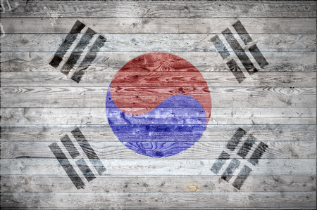 A vignetted background image of the flag of South Korea onto wooden boards of a wall or floor.の写真素材
