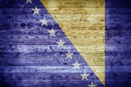 A vignetted background image of the flag of Bosnia and Herzegovina painted onto wooden boards of a wall or floor.の写真素材