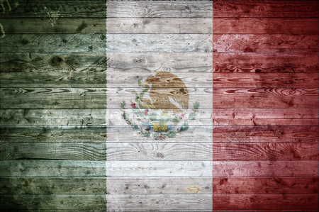 A vignetted background image of the flag of Mexico painted onto wooden boards of a wall or floor.の写真素材