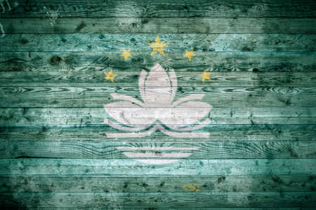 A vignetted background image of the flag of Macau painted onto wooden boards of a wall or floor.の写真素材