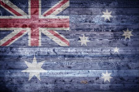 A vignetted background image of the flag of Australia painted onto wooden boards of a wall or floor.の写真素材