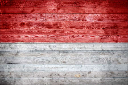 A vignetted background image of the flag of Monaco painted onto wooden boards of a wall or floor.の写真素材