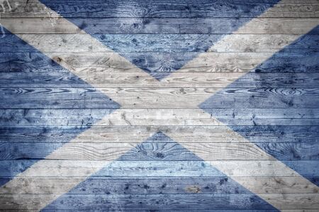 A vignetted background image of the flag of Scotland onto wooden boards of a wall or floor.の写真素材