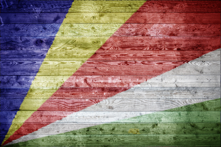A vignetted background image of the flag of Seychelles onto wooden boards of a wall or floor.の写真素材