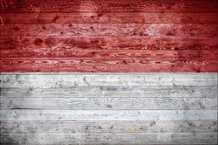 A vignetted background image of the flag of Indonesia painted onto wooden boards of a wall or floor.の写真素材
