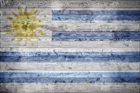 A vignetted background image of the flag of Uruguay onto wooden boards of a wall or floor.の写真素材