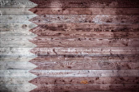 A vignetted background image of the flag of Qatar onto wooden boards of a wall or floor.の写真素材