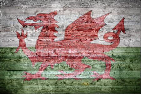 A vignetted background image of the flag of Wales onto wooden boards of a wall or floor.の写真素材