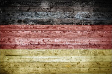 A vignetted background image of the flag of Germany painted onto wooden boards of a wall or floor.の写真素材