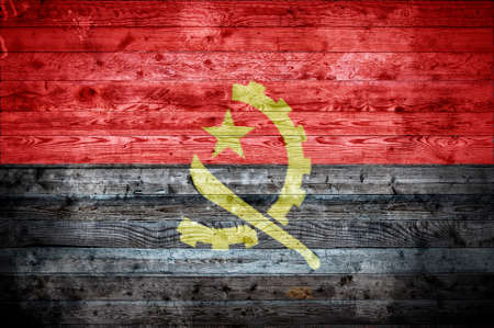 A vignetted background image of the flag of Angola painted onto wooden boards of a wall or floor.の写真素材